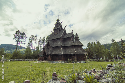 Urnes stavkirke at highland landscape photo. Beautiful nature scenery photography with cloudy sky on background. Idyllic scene. High quality picture for wallpaper, travel blog, magazine, article