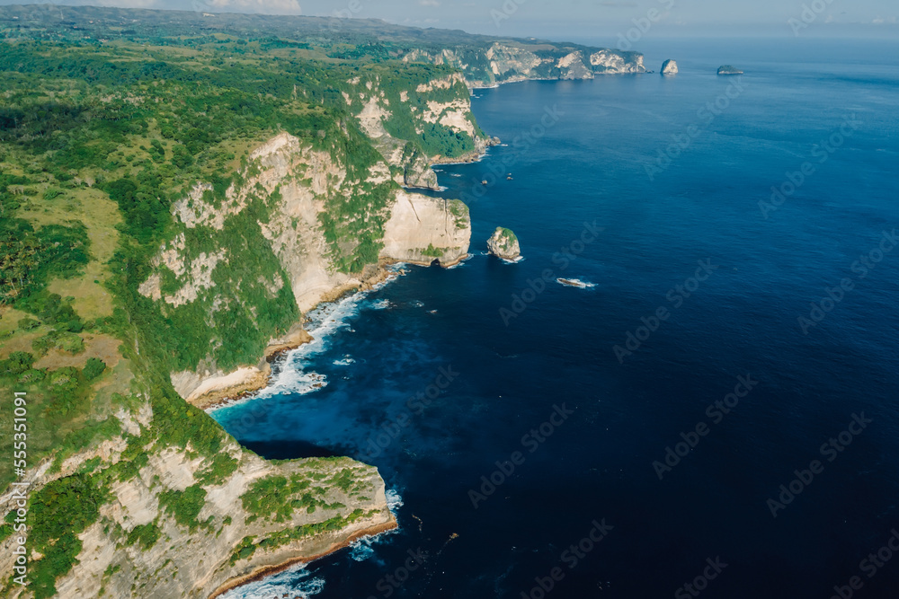 Aerial view of coastline with cliffs and blue ocean in Nusa Penida island, Indonesia. Aerial view of coastline with cliffs and blue ocean in Nusa Penida island, Indonesia.