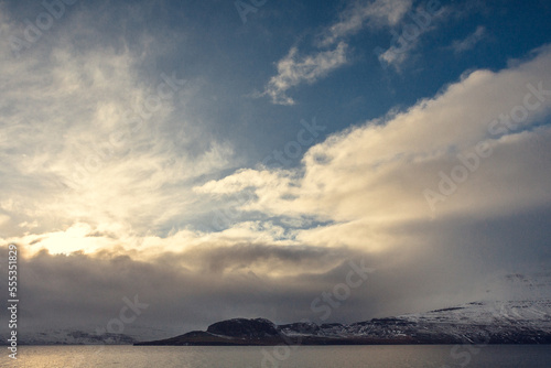 Snowy mountains on sea coast landscape photo. Beautiful nature scenery photography with cloudscape on background. Idyllic scene. High quality picture for wallpaper, travel blog, magazine, article