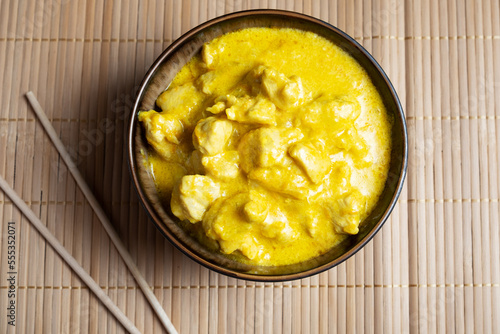 Spicy chicken in curry sauce on a bamboo napkin with chopsticks. Dish of Asian cuisine photo