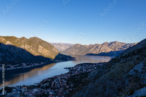 Panoramic view of the bay of Kotor during sunrise in summer, Adriatic Mediterranean Sea, Montenegro, Balkan Peninsula, Europe. Fjord winding along the coastal towns. First sunbeams on Lovcen mountains