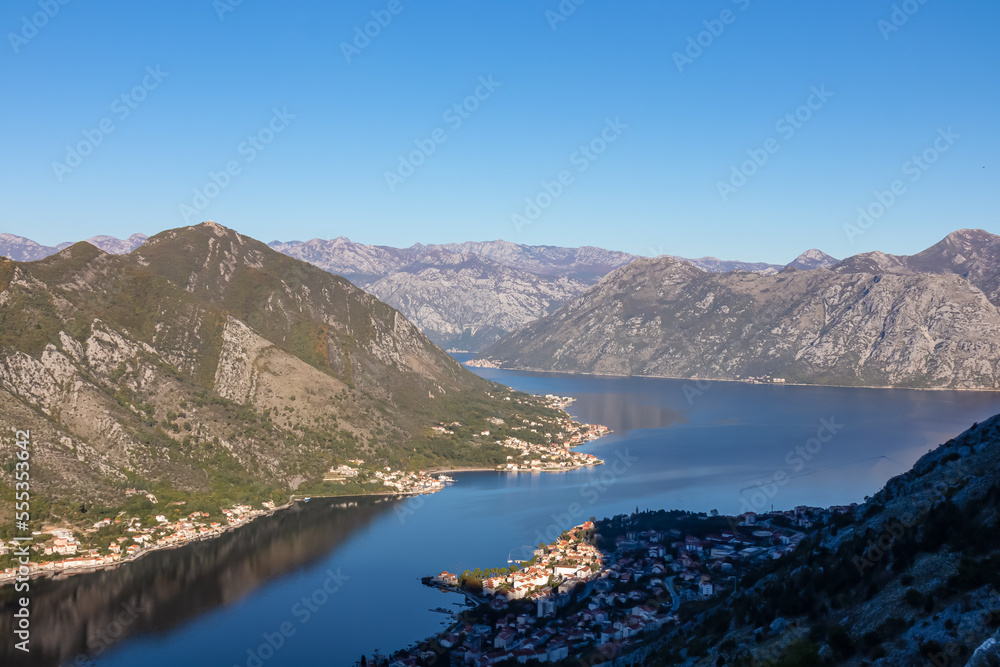 Panoramic view of the bay of Kotor during sunrise in summer, Adriatic Mediterranean Sea, Montenegro, Balkan Peninsula, Europe. Fjord winding along the coastal towns. First sunbeams on Lovcen mountains