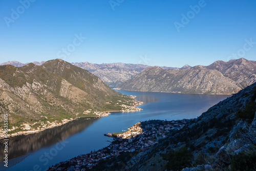 Panoramic view of the bay of Kotor during sunrise in summer, Adriatic Mediterranean Sea, Montenegro, Balkan Peninsula, Europe. Fjord winding along the coastal towns. First sunbeams on Lovcen mountains