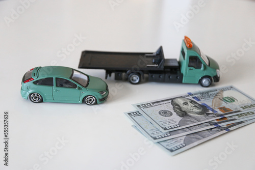 Tow truck with a stack of money. Call a tow truck for a broken car. High price