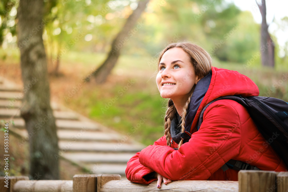 Smiling young female hiker contemplating views in the forest. Smiling young female hiker contemplating views in the forest.