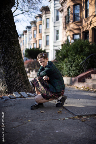 non-binary caucasian person with short hair posing on Brooklyn sidewalk