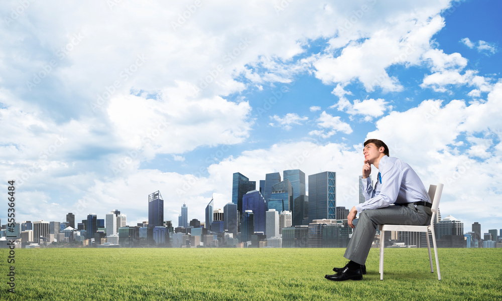 Young businessman sitting on an office chair Young businessman sitting on an office chair