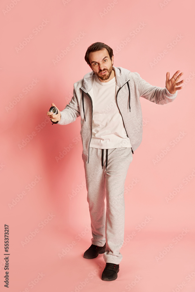 Active happy man with beard wearing home sportswear doing exercises isolated over pink background. Concept of active lifestyle, positive emotions, sport Active happy man with beard wearing home sportswear doing exercises isolated over pink background. Concept of active lifestyle, positive emotions, sport