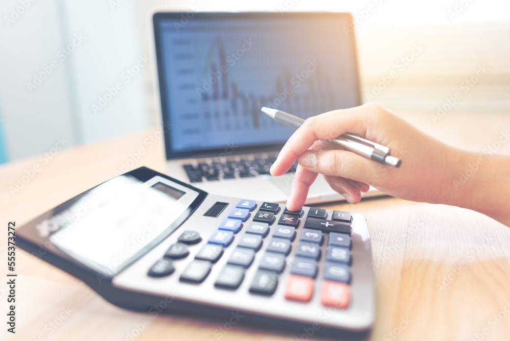 The accountant has a calculator and a laptop computer on his desk. The accountant has a calculator and a laptop computer on his desk.
