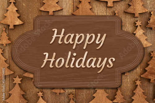 Happy Holidays greeting on a brown wood sign over trees