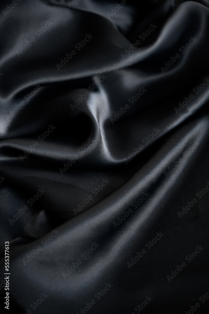 Fototapeta premium Silk background. Elegant black satin silk with waves, abstract background