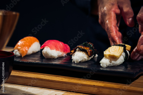 Japanese chef making rice nigiri sushi with tuna, salmon, shrimp,traditional Japanese food ,Dark Tone
