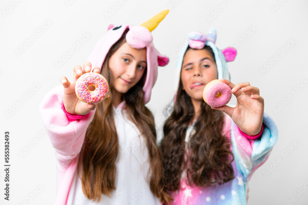 Friends girls with unicorn pajamas over isolated white background