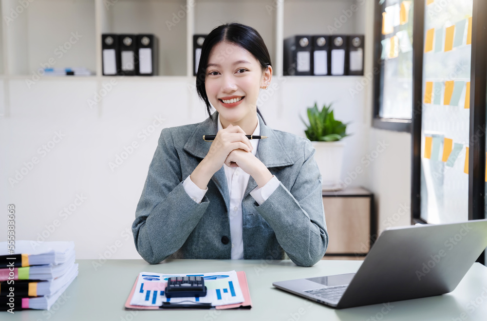 Female asian sitting at the desk, looking to camera. Female asian sitting at the desk, looking to camera.
