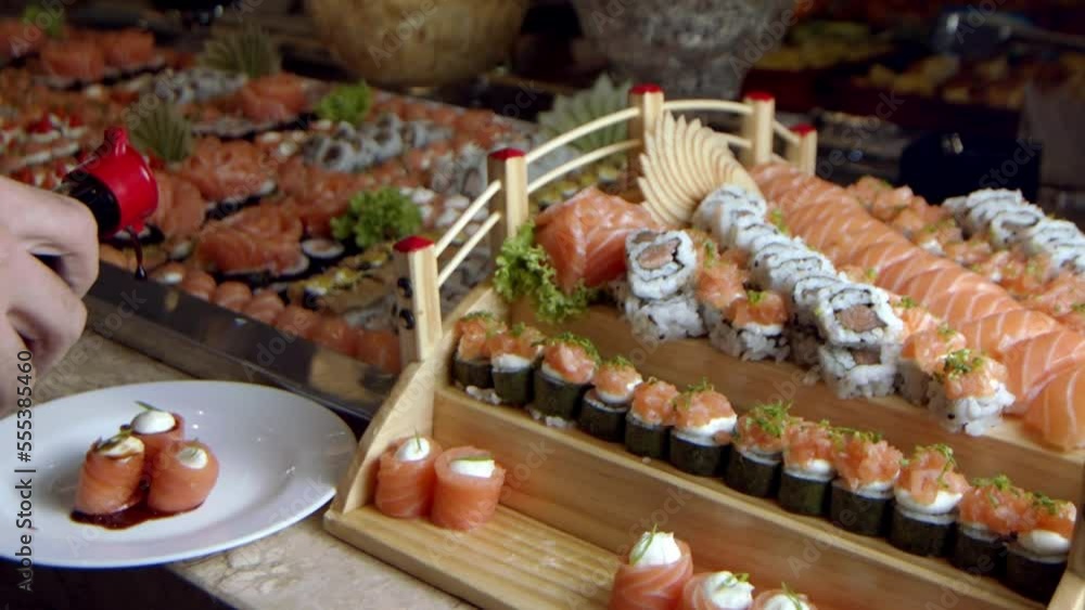 Person pouring soy sauce on some sushi pieces in slow motion in an upscale Asian restaurant. Person pouring soy sauce on some sushi pieces in slow motion in an upscale Asian restaurant.