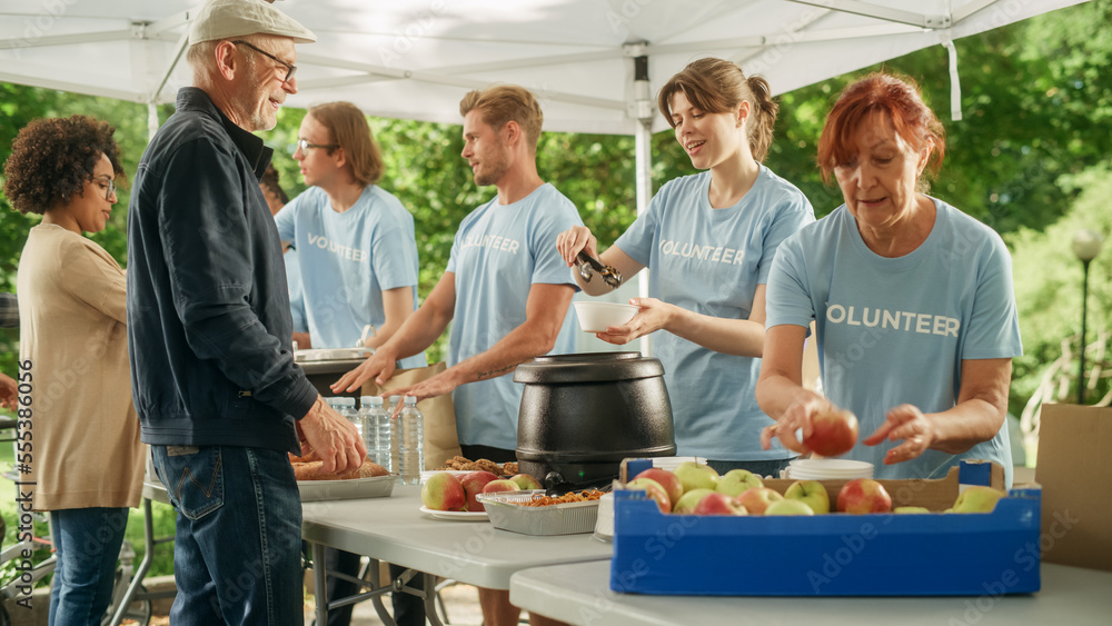 The Concept of Giving: Homeless People Reach Out To Free Volunteer Meals from Multiethnic Team of Volunteers. Humanitarian Aid Charity Workers Serve Meals to People in Need. The Concept of Giving: Homeless People Reach Out To Free Volunteer Meals from Multiethnic Team of Volunteers. Humanitarian Aid Charity Workers Serve Meals to People in Need.