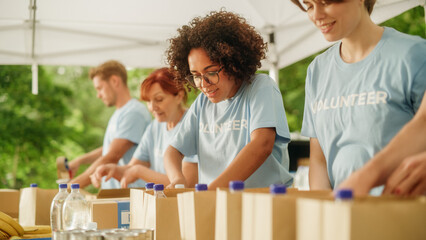 Portrait of a Happy Female Volunteer Preparing Free Food Delivery for Low Income People. Charity Workers and Members of the Community Work Together in Local Humanitarian Aid Donation Center.