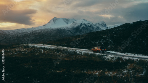 car driving along snowy mountains