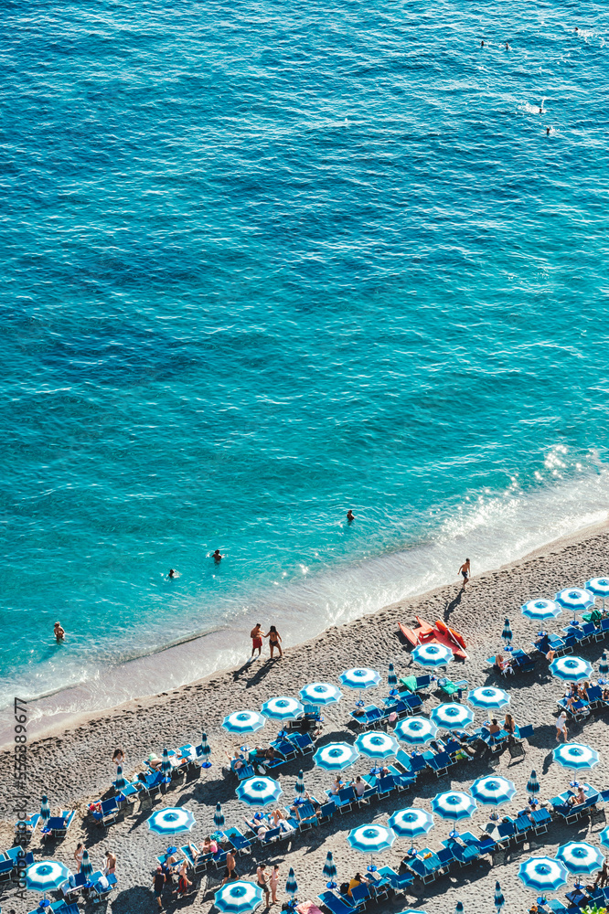 Blue beach umbrellas and the beautiful shoreline of the beach at Positano on the Amalfi Coast. Blue beach umbrellas and the beautiful shoreline of the beach at Positano on the Amalfi Coast.