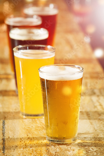 Alcohol  beer and glasses at a bar table for party  club and happy hour promotion  sale and commercial background for event. Social lifestyle  drink and group of ale glasses at pub for cocktail sale