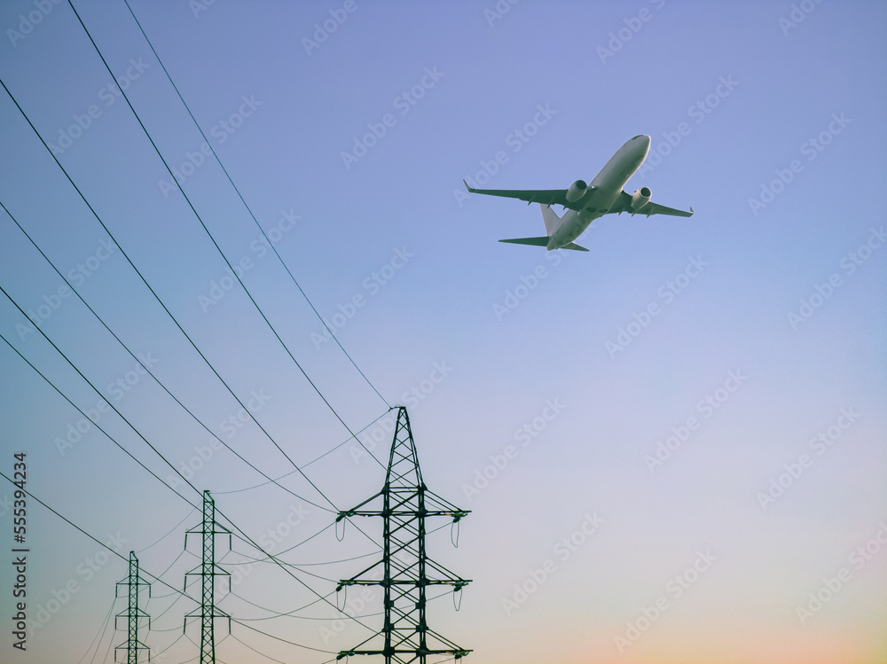 High voltage electricity power line towers against the sky. Airplane ...