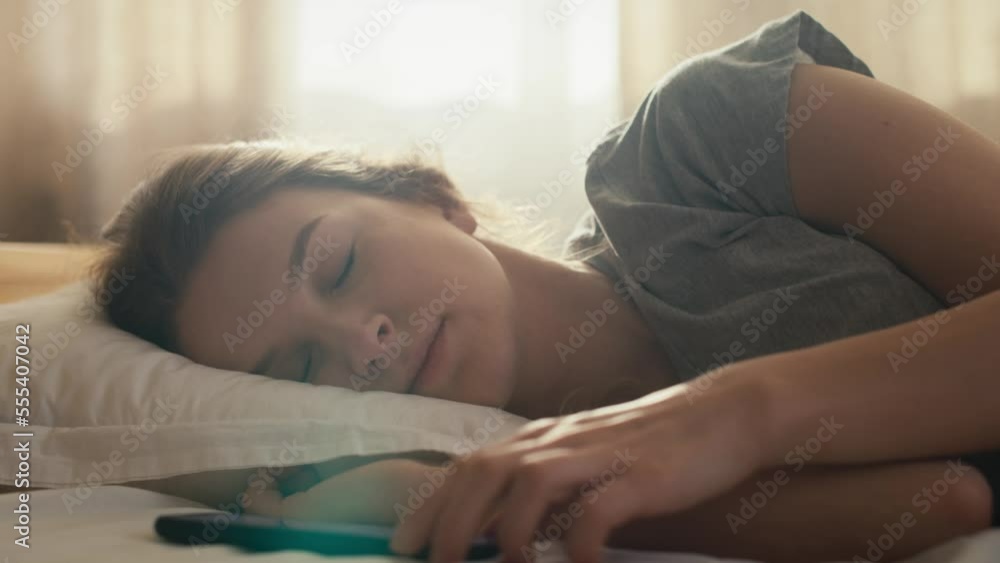 Caucasian woman turn off the alarm clock and waking up at morning. Shot with RED helium camera in 8K. Caucasian woman turn off the alarm clock and waking up at morning. Shot with RED helium camera in 8K.