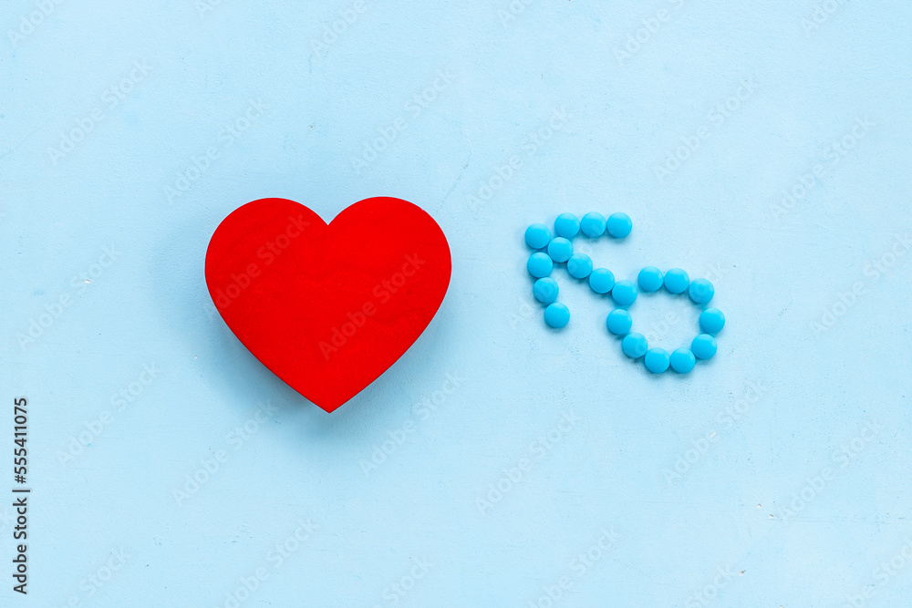 Male sign made of blue pills with red heart. Male medical checkup concept