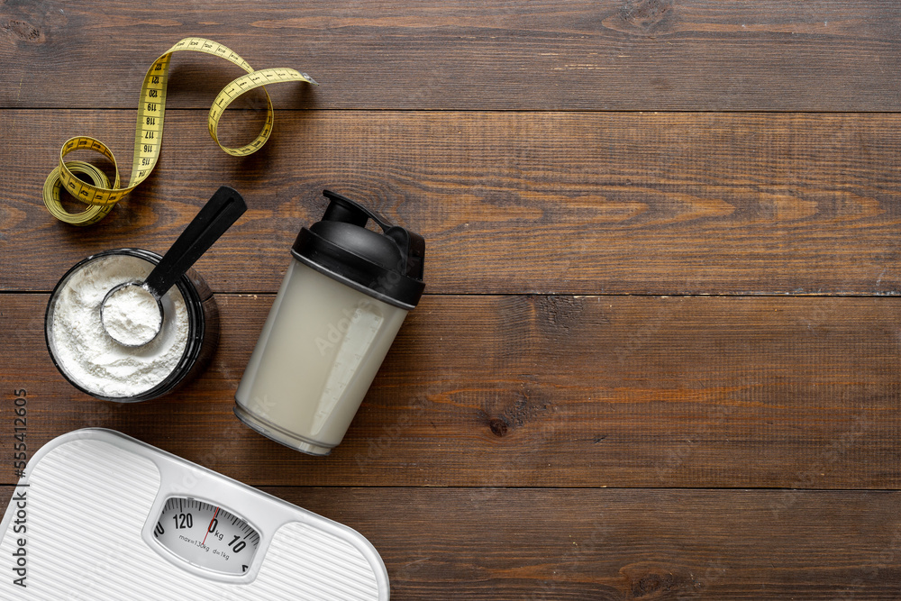 Sport diet food - whey protein in jar and scales. Fitness and gym concept Sport diet food - whey protein in jar and scales. Fitness and gym concept