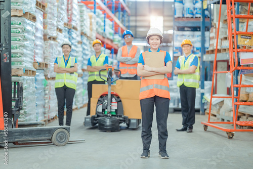 Smiling warehouse team with arms crossed in a large warehouse ,Logistics industry concept.