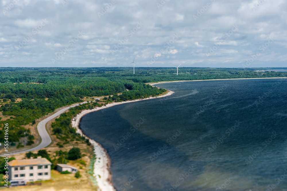 Wind generators turbines on the seashore in forested area, clean and renewable energy production 