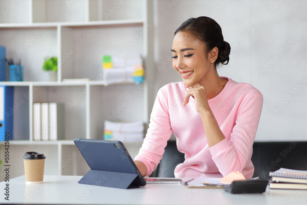 Woman in home office using tablet and mobile phone writing work schedule on notepad, Working from home. Woman in home office using tablet and mobile phone writing work schedule on notepad, Working from home.