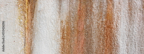 Orange and Brown Streaks on a Pale White Plaster Wall. Rustic background.