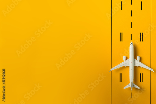 Travel concept. Top view of Jet airliner on yellow runway background with copy space. Online flight purchase, flight tickets booking