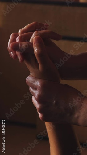 hands of unrecognizable practitioner passing patient's hand and wrist, Ayurveda treatment, vertical video, HD