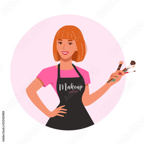 Beautiful makeup artist with red hairs holding proffesional brushes. Young woman make up stylist in apron with equipment for visage