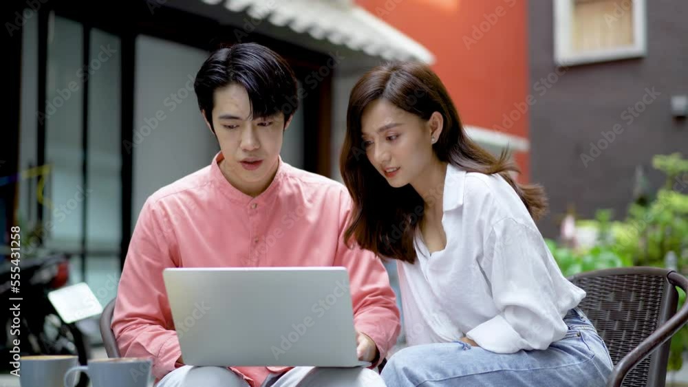Modern couple surfing on internet during coffee break at cafe, Happy Young man and woman drinking coffee and shopping online or discussing to project planning on laptop in restaurant Modern couple surfing on internet during coffee break at cafe, Happy Young man and woman drinking coffee and shopping online or discussing to project planning on laptop in restaurant