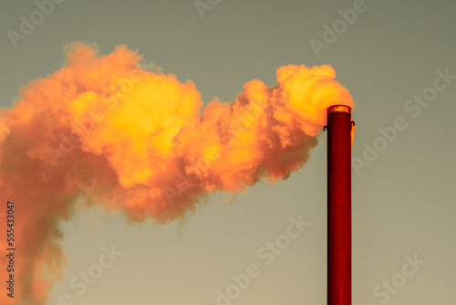 Thick and toxic smoke coming out of a chemical factory chimney under a sky background