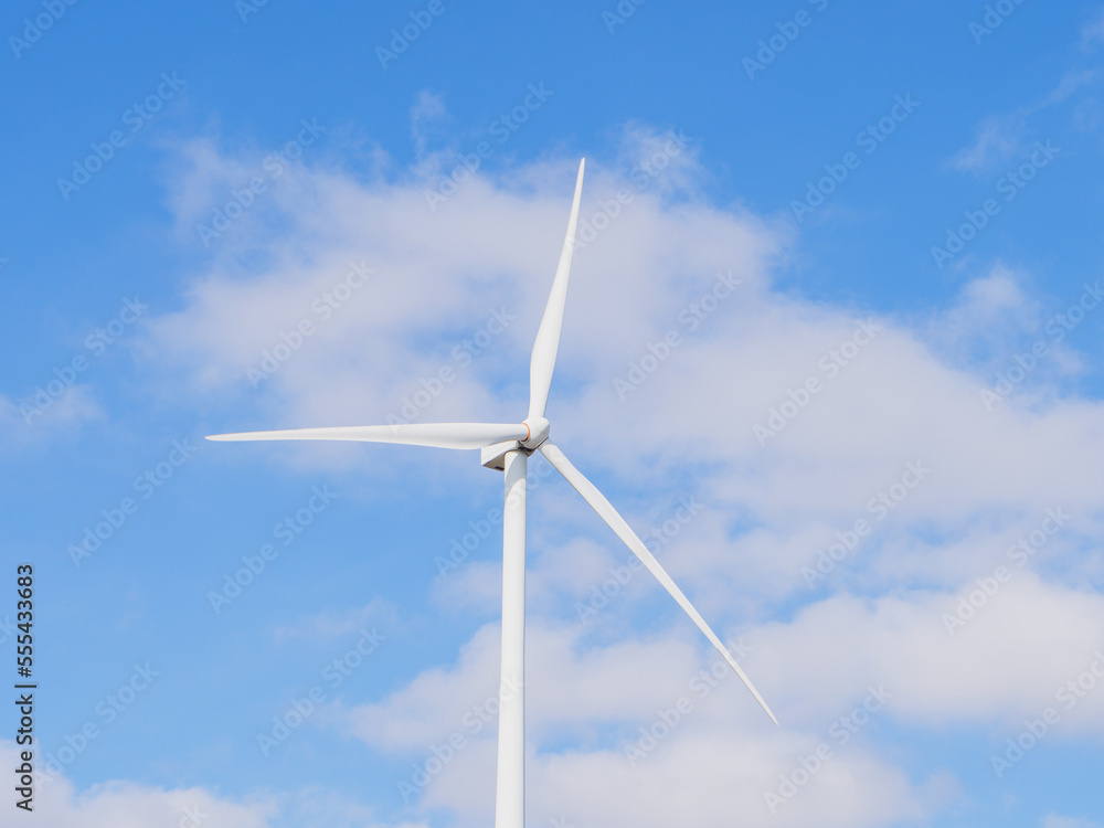 Close-up of Wind electric generator. Wind generators stand in agricultural fields with Powerful wind turbine farms for pure energy production on the background. Close-up of Wind electric generator. Wind generators stand in agricultural fields with Powerful wind turbine farms for pure energy production on the background.