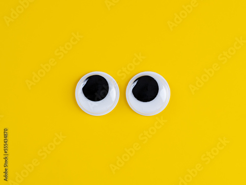 Cute googly eyes funny Isolated on bright yellow background copy space logo