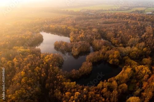 Aerial view above Walton Colliery Nature Park with Autumn woodland and lake in Wakefield