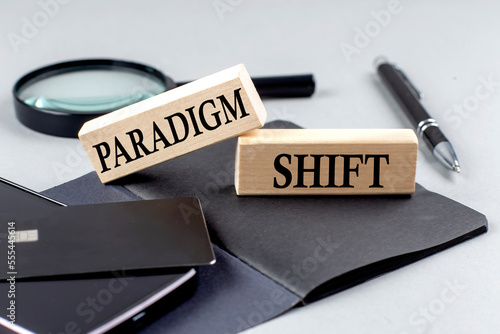 PARADIGM SHIFT text on wooden block on black notebook , business concept