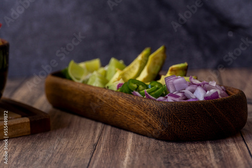 Fototapeta Naklejka Na Ścianę i Meble -  lemon and avocado on a wooden plate to put on meat, traditional mexican food
