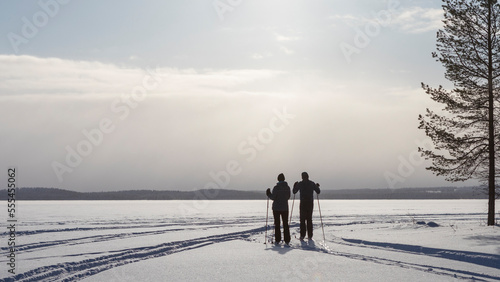 person walk2 cross-country skiers on a frozen lakeing in the snow