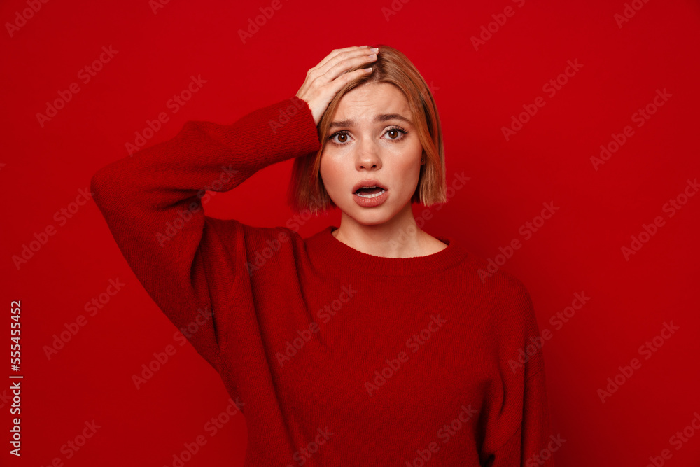 Fototapeta premium Confused woman touching her head and looking at camera isolated