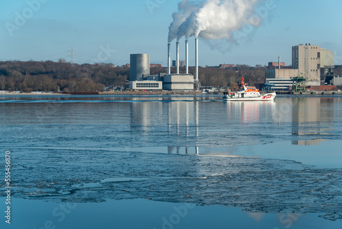 Gefrorenes Wasser in der Kieler Förde an einem Sonnigen kalten Wintertag der Seenotkreuzer Hackmack fährt vorbei photo