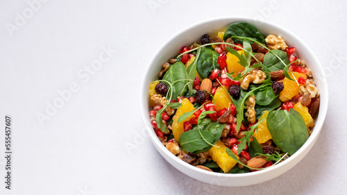 Wallpaper Mural Healthy salad with spelt, oranges, pomegranate seeds. greens and nuts on light background, minimal style Torontodigital.ca