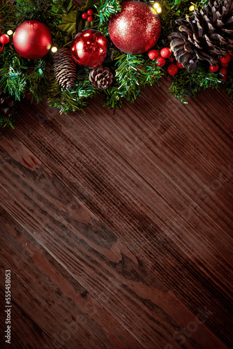 Christmas decorations and fir branches on wooden board background with copy space. Wooden new year background, wooden surface, green tree, red berries