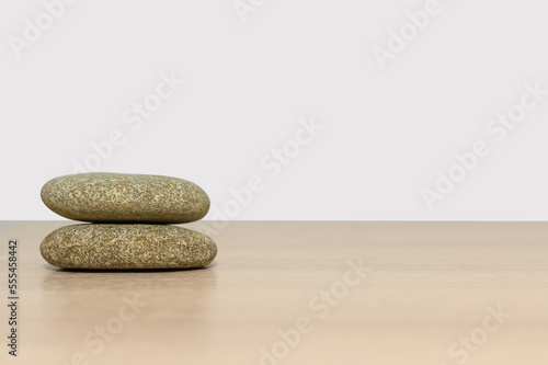 Two round stones on a wooden surface. Empty space for design.