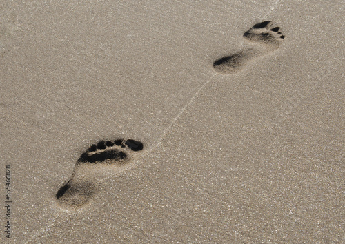 Footprints on a beach tide line; Bamburgh, Northumberland England photo
