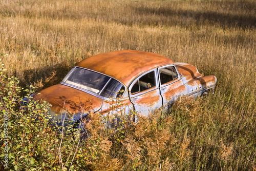 A vintage car abandoned in a field; Creston, British Columbia, Canada photo